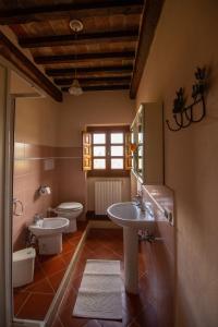 Un baño con dos lavabos y un inodoro. en Collina dei Fiori, en Castiglion Fiorentino