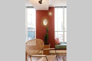 a living room with a chair and a red wall at Appartement chaleureux en centre-ville de Caen in Caen