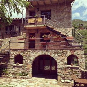 un bâtiment en pierre avec un escalier et un balcon. dans l'établissement Cal Xesc, à Castellar de n'Hug