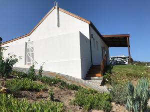 a church with a white building at Stylish Country Cottage, Solar panelled in Knysna in Knysna