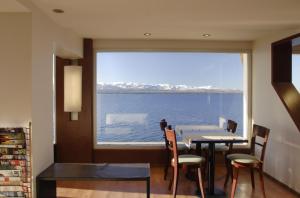 een eetkamer met een tafel en een groot raam bij Hotel Bariloche Flat in Bariloche +52 foto's
