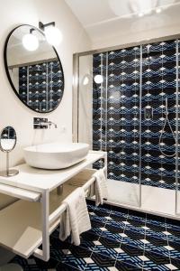 a bathroom with a sink and a glass shower at Toraldo Suites - Dimore Partenopee in Naples +37 photos