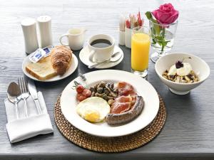 a table with a plate of breakfast foods and coffee at Mont d'Or Franschhoek in Franschhoek