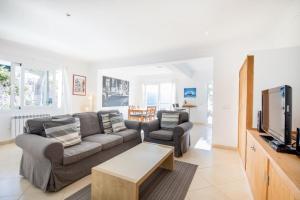 a living room with a couch and a tv at Mestral in Port de Soller