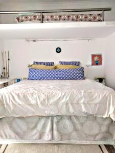 ein Schlafzimmer mit einem weißen Bett mit blauen und weißen Kissen in der Unterkunft Zamboli in Chania