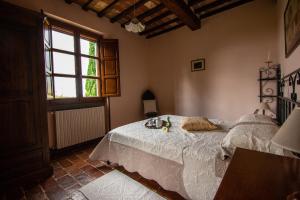 un dormitorio con una cama y una ventana en Collina dei Fiori, en Castiglion Fiorentino 41 fotos más