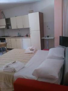 una camera da letto con un grande letto con asciugamani bianchi di Appartamenti Centro Policastro a Policastro Bussentino