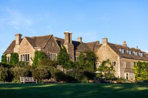a large house with a lawn in front of it at Whatley Manor in Malmesbury