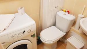 a bathroom with a toilet and a washing machine at Birch view apartment in Jelgava