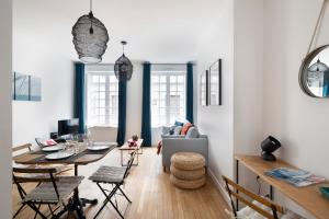 a living room with a table and a couch at Le Code 0 by Cocoonr in Saint Malo