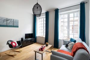 een woonkamer met een bank en een tv bij Le Code 0 by Cocoonr in Saint-Malo
