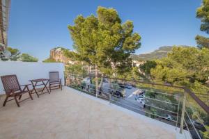 a balcony with two chairs and a table and trees at Ponent in Port de Soller