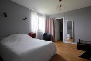 a bedroom with a bed and a chair and a window at Logis Hotel Le Relais du Teulet in Goulles