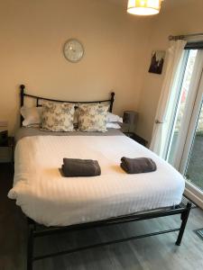 a bedroom with a large bed with two pillows on it at Ty Mynydd Lodge Holiday Home in Cardiff
