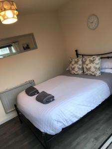 1 cama en un dormitorio con reloj en la pared en Ty Mynydd Lodge Holiday Home en Cardiff