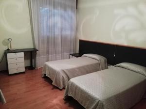 - une chambre avec 2 lits, une commode et une fenêtre dans l'établissement bar Nuovo Mondo, à Mussolino