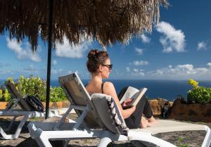 布雷尼亞瓦哈的住宿－Corral de Payo Grande，坐在沙滩椅上的女士,带一本书