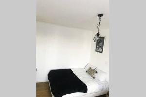a bedroom with a black and white bed in a room at Le Convivial Ethnique-Pont Rousseau studio T1bis in Rezé