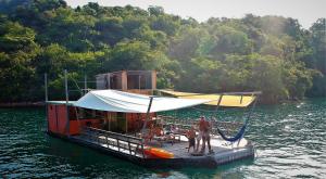 a group of people standing on a boat in the water at Casa Flutuante Ilha Grande Rj in Praia do Bananal