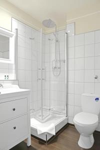 a white toilet sitting next to a bath tub in a bathroom at Hotel Stralsund in Stralsund