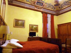 a bedroom with a bed and a desk with a computer at Albergo Ristorante Cavallo Bianco in Dronero