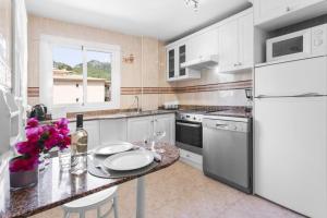 a kitchen with a table and a white refrigerator at S Olivera in Port de Soller
