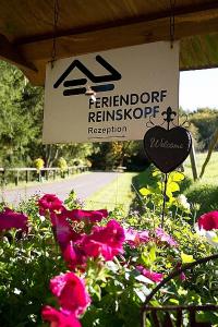 a sign for a flower garden with pink flowers at Haus 2 - Typ A (Appartement) in Schönecken