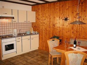 a kitchen with a table with chairs and a kitchen with a stove at Haus 2 - Typ A (Appartement) in Schönecken