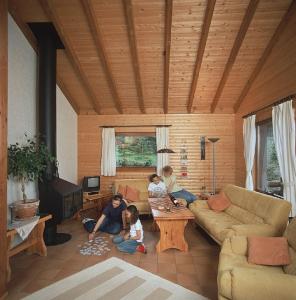 a group of people sitting in a living room at Haus 1 - Typ B (Blockhaus) in Schönecken