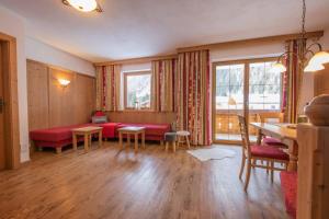a living room with a red couch and a table at Alpenchalet Vital in Neustift im Stubaital
