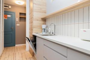 a kitchen with a sink and a blue door at Seaside Apartment Kraszewskiego by the Beach in Sopot by Renters in Sopot