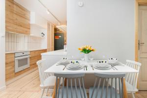 a kitchen and dining room with a white table and chairs at Seaside Apartment Kraszewskiego by the Beach in Sopot by Renters in Sopot