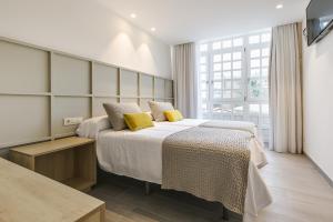 a bedroom with a large bed with yellow pillows at A Casa do Latoneiro in Caldas de Reis