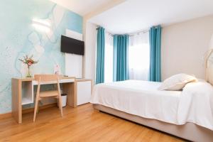 a bedroom with a bed and a desk and a table at Hotel Castilla Alicante in Alicante