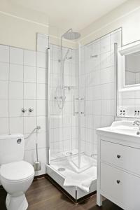 a white toilet sitting next to a bath tub in a bathroom at Hotel Stralsund in Stralsund