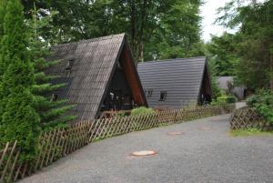 ein Haus mit einem Holzzaun neben einem Gebäude in der Unterkunft Holiday park- Nurdach in Clausthal