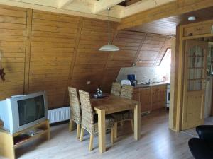 a dining room with a wooden table and a tv at Holiday park- Nurdach in Clausthal