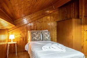 una cama en una habitación con una pared de madera en Il Terrazzino sul Lago, en Bellagio