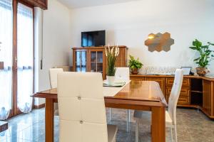 een eetkamer met een houten tafel en witte stoelen bij Il Terrazzino sul Lago in Bellagio