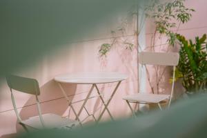 チェンマイにあるマンモス ブティック ホテルの植物のある部屋(テーブルと椅子2脚付)