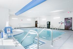 a swimming pool in a hospital room with chairs at Cobblestone Hotel & Suites - Janesville in Janesville