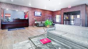 a lobby with a couch and a bar at Cobblestone Hotel & Suites - Janesville in Janesville