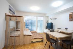 een slaapkamer met een stapelbed, een bureau en een tafel bij Studio Novak Bled in Bled