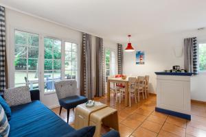 a living room with a blue couch and a table at Village Pierre & Vacances Moliets in Moliets-et-Maa