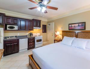 a bedroom with a white bed and a kitchen at Chipman Hill Suites - Union Street in Saint John