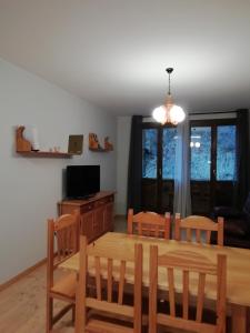 uma sala de jantar com uma mesa de madeira e cadeiras em Apartamento Viman em Canfranc-Estación