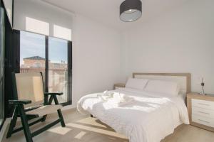 a bedroom with a bed and a chair and a window at 58 Luxury Sunny Vacations in La Mata +23 photos
