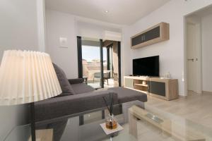 a living room with a couch and a television at 58 Luxury Sunny Vacations in La Mata