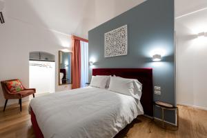 um quarto com uma cama grande e uma cadeira em I Colori della Puglia Rooms em Trani