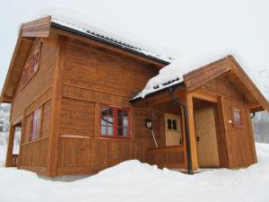 Cabaña de madera con nieve en el techo en Hemsedal Høyfjellssenter en Hemsedal